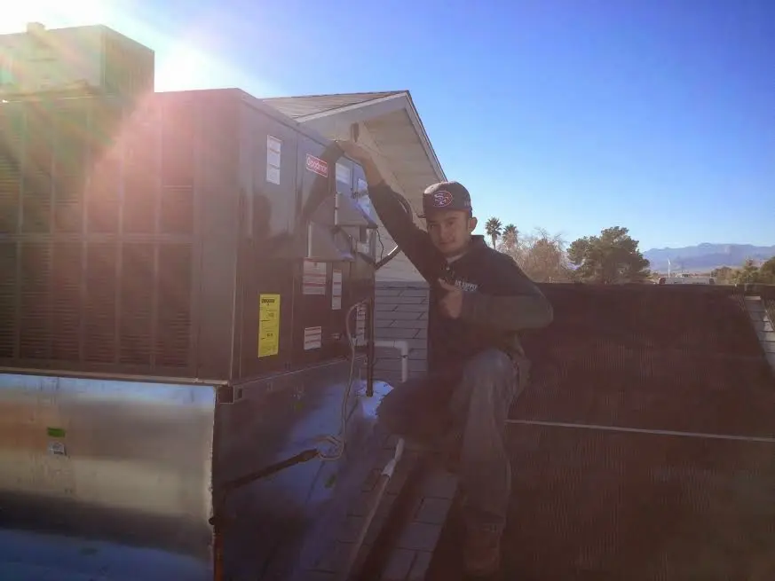 HVAC technician performing AC Tune-Up on a rooftop unit in Eagleton Village